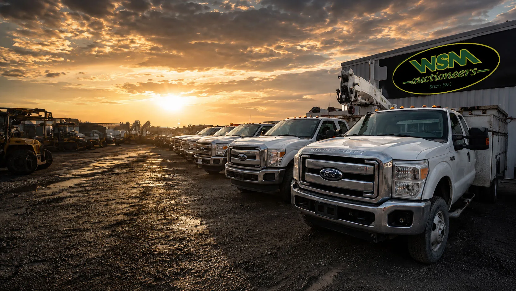 Utility trucks and equipment lined up in the WSM Auctioneers yard at sunset, Phoenix